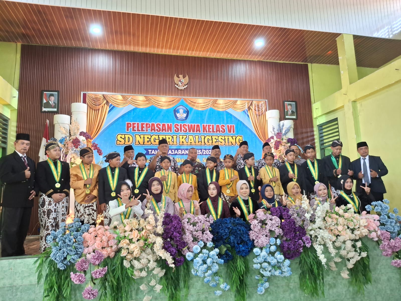 FOTO BERSAMA: Siswa, guru, dan tamu undangan berfoto bersama dalam acara pelepasan siswa kelas VI SD Negeri Kaligesing di Gedung KPRI Kaligesing, Kecamatan Kaligesing, Kabupaten Purworejo, Kamis (4/6). Prestasi peringkat pertama TKA tingkat Kecamatan Kaligesing menjadi kebanggaan dalam acara tersebut.
